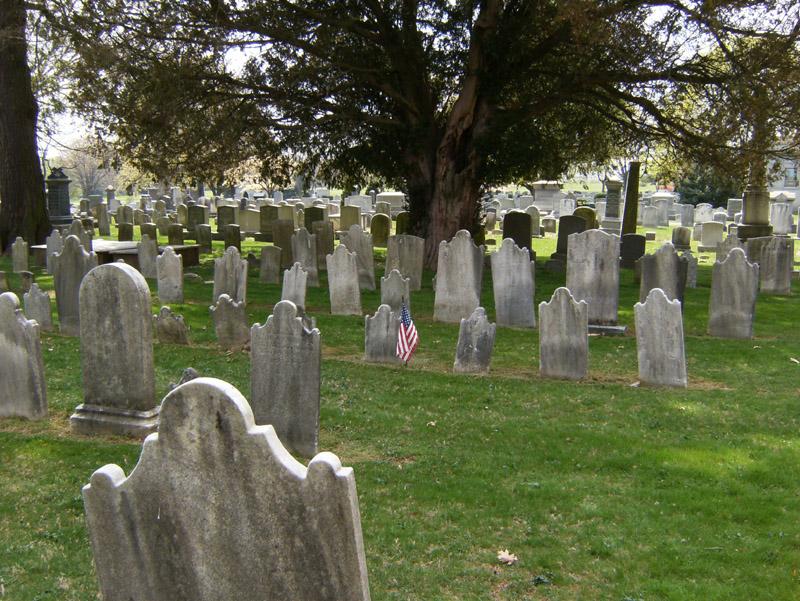 cemetery with American flag next to headstone cemetery with American flag next to headstone