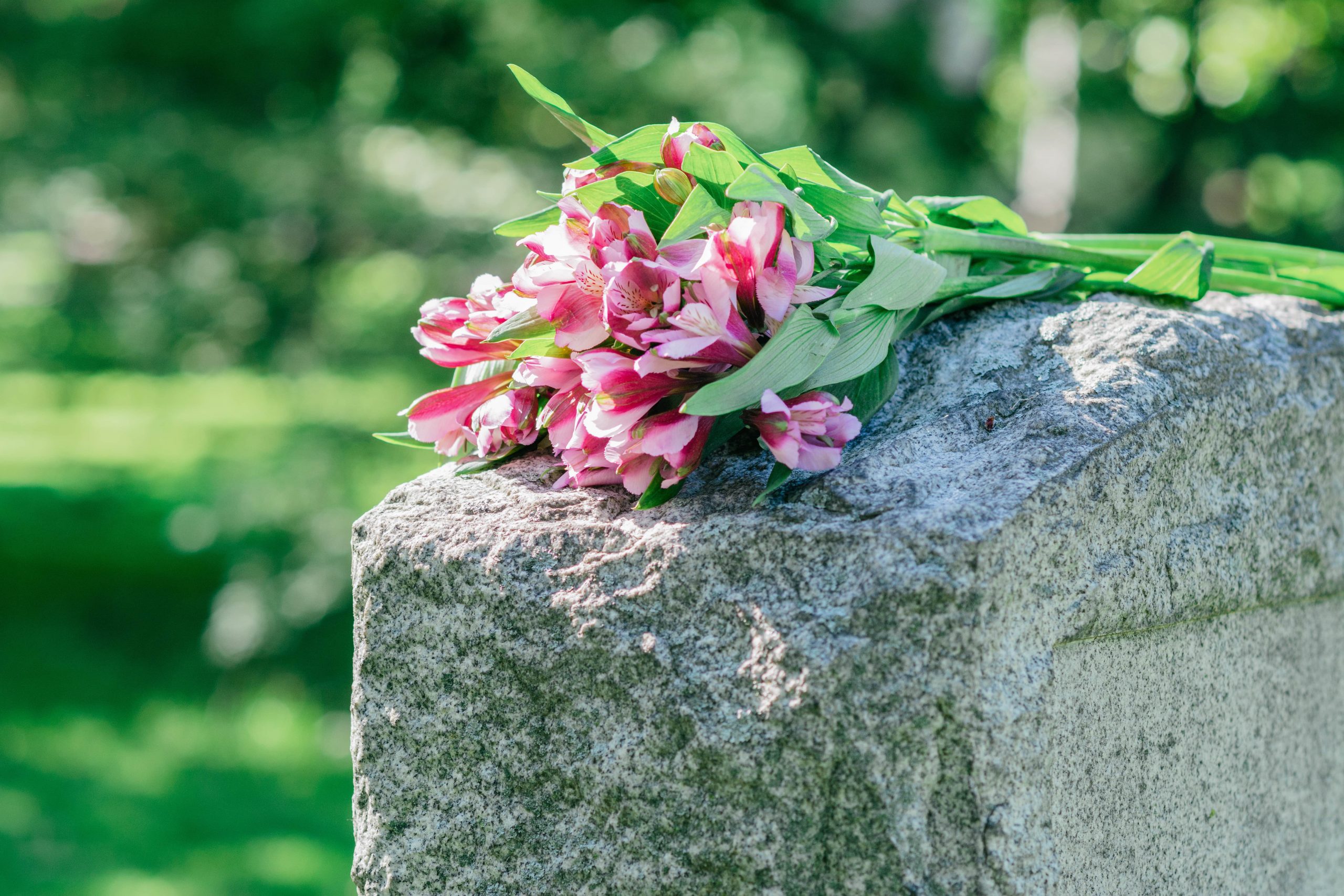 bouquet of pink flowers on top of tombstone bouquet of pink flowers on top of tombstone
