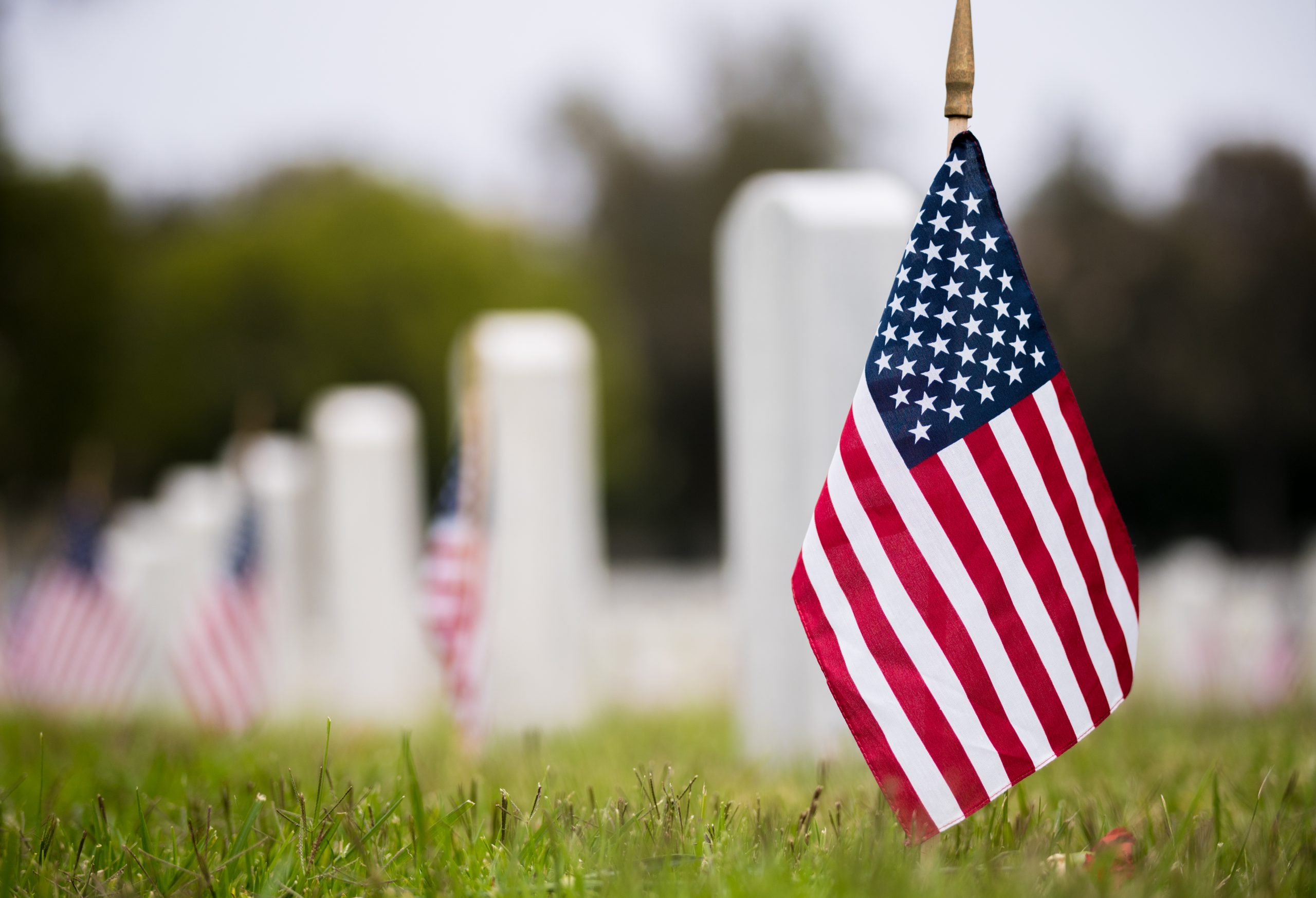 American flag in front of gravestone American flag in front of gravestone